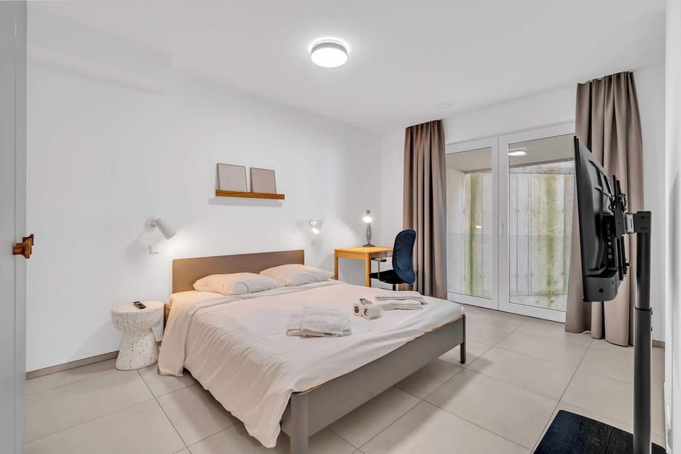 Bright bedroom with comfortable bed and direct access to the outdoor space.