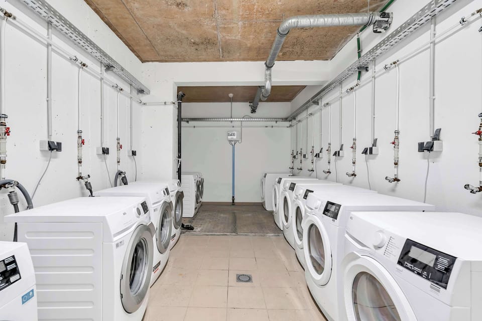 Shared laundry room equipped with multiple washers and dryers for everyday convenience.