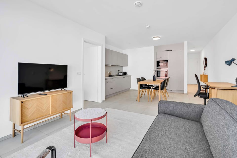 Living space with TV and seating area, connected seamlessly to the kitchen.