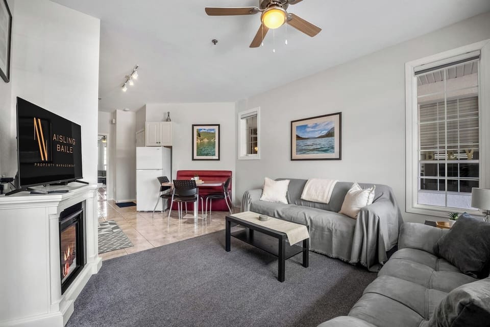 Living room with an electric fireplace, Smart TV, walkout access to the ground-floor patio, and cozy seating options with a double-sized sleeper sofa (all linens provided.)