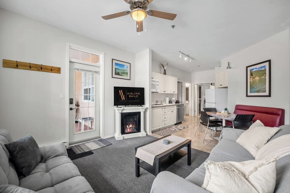Living room with an electric fireplace, Smart TV, walkout access to the ground-floor patio, and cozy seating options with a double-sized sleeper sofa (all linens provided.)