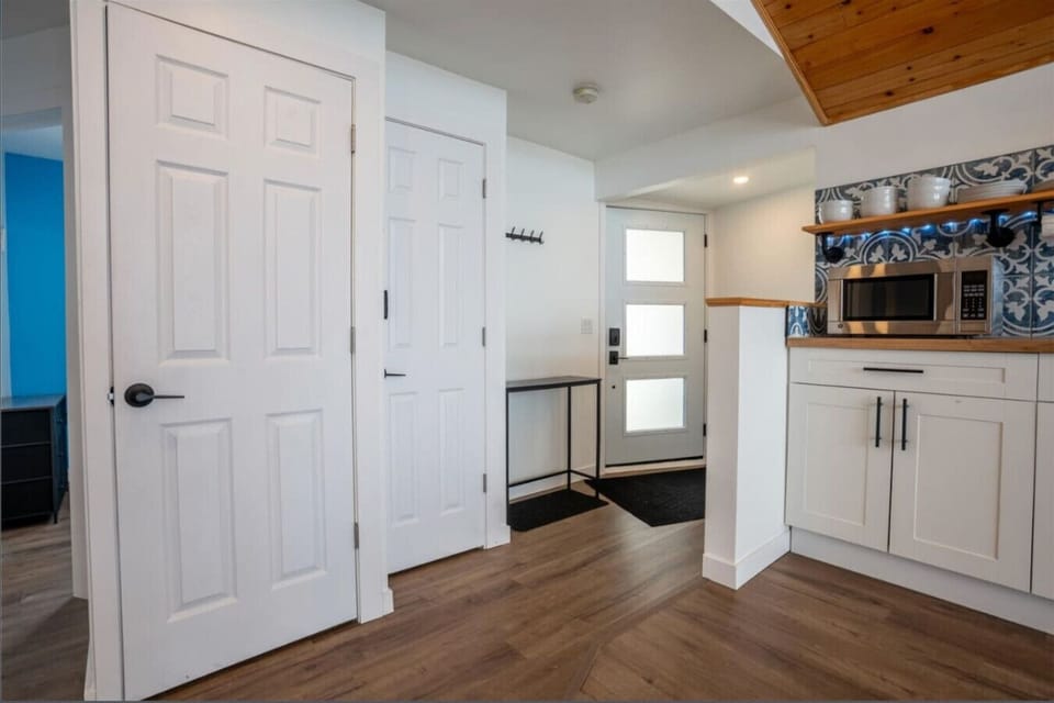 Open-Concept Design: The kitchen flows seamlessly into a dining area with vaulted wood ceilings, perfect for hosting family dinners.  Panoramic Windows: Prepare meals while enjoying floor-to-ceiling views of the sparkling lake waters.