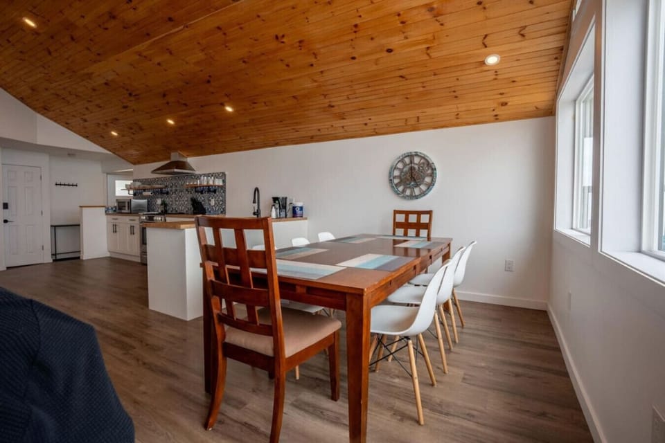 Open-Concept Design: The kitchen flows seamlessly into a dining area with vaulted wood ceilings, perfect for hosting family dinners.  Panoramic Windows: Prepare meals while enjoying floor-to-ceiling views of the sparkling lake waters.