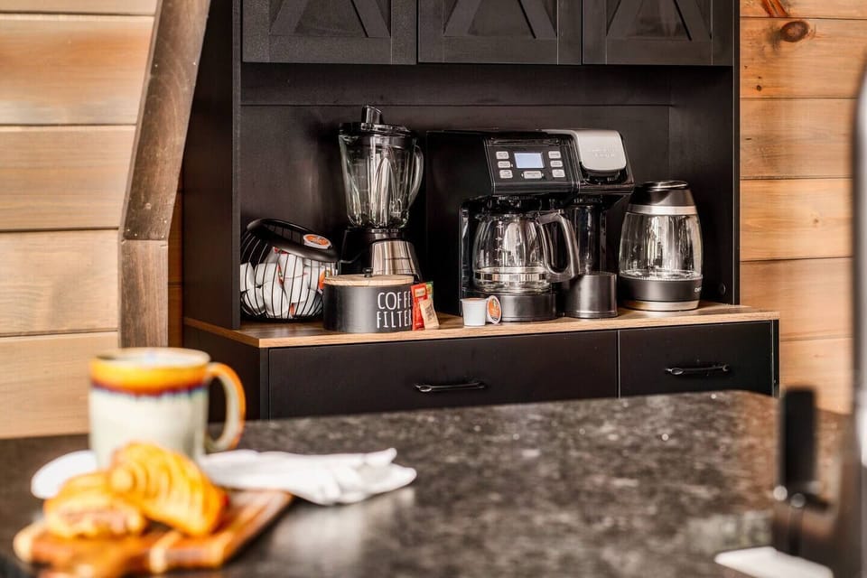 Cozy coffee station tucked away for your morning routine, complete with multiple brewing options and cabin charm.
