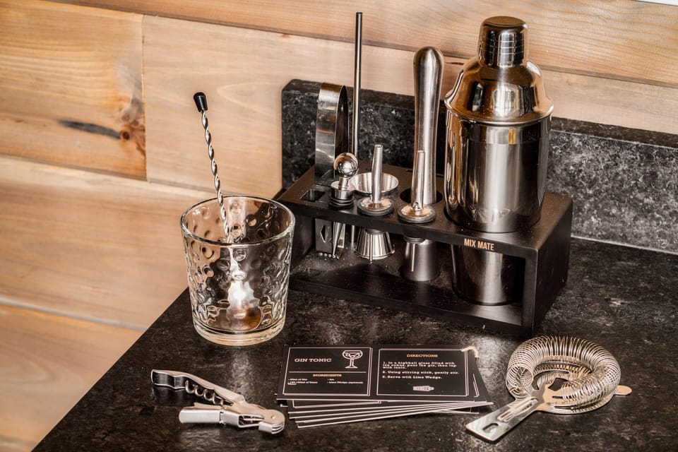 Well-equipped bar setup with cocktail tools and recipe cards, perfect for mixing drinks and elevating your stay.