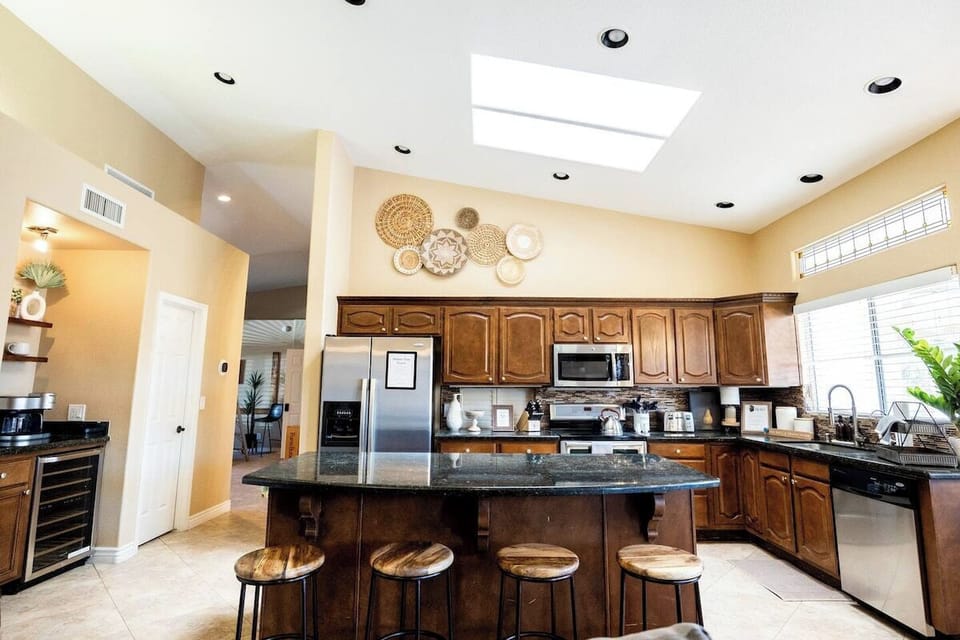 Large open concept kitchen and wine fridge are with a coffee station.
