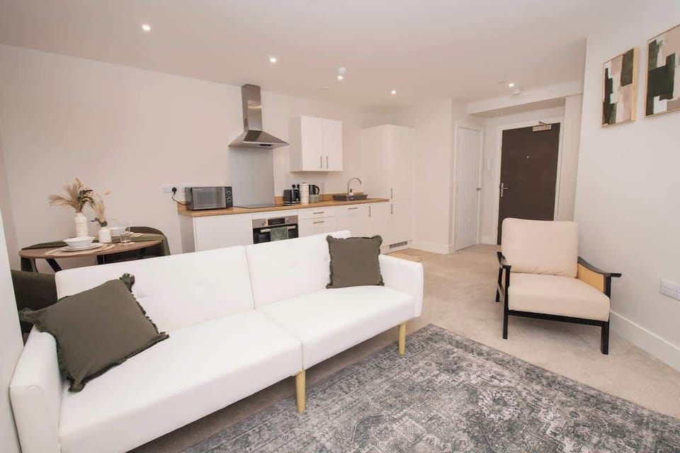 Unwind in our cozy living room featuring a smart TV for movie nights, with a spacious open-plan layout that flows seamlessly into the kitchen and dining area.