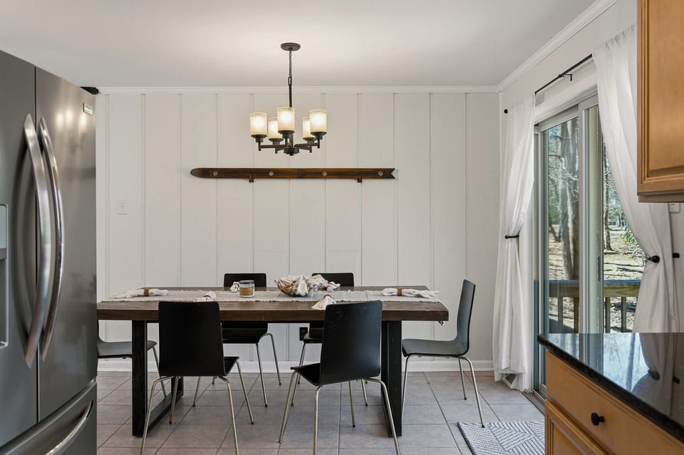 Sleek dining area with seating for six and a view of the forest.