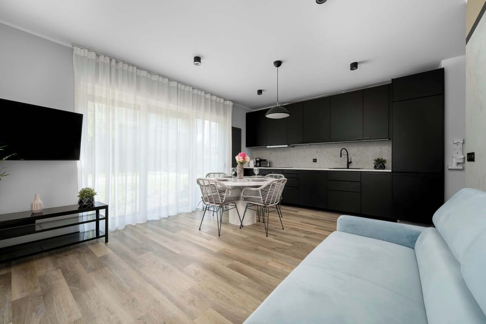 This angle captures the entire social space, showing the kitchenette, dining table, and the lounge area together. The layout is open and highly functional for guests.