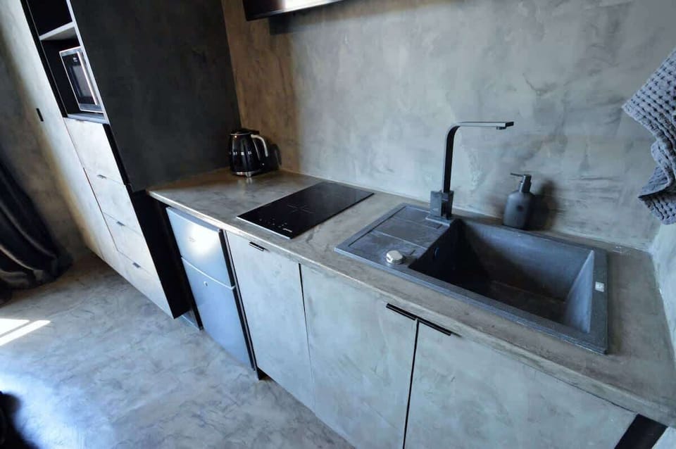 The kitchenette offers a microwave, small fridge, stove-top, dishwasher, kettle, toaster, crockery/cutlery for two guests.