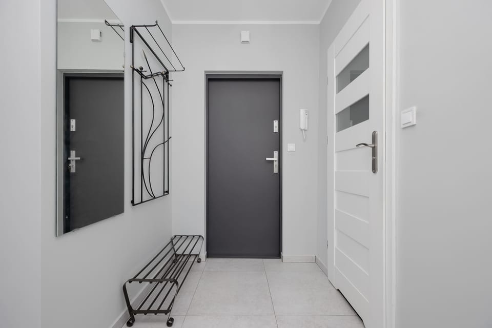 A hallway area with doors and wall hooks for coats. The space is practical and neatly arranged.