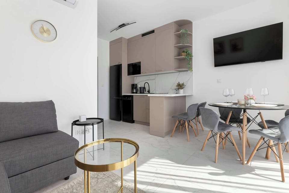 An open-plan living space combining a sitting area, dining table, and kitchen in a cohesive layout.