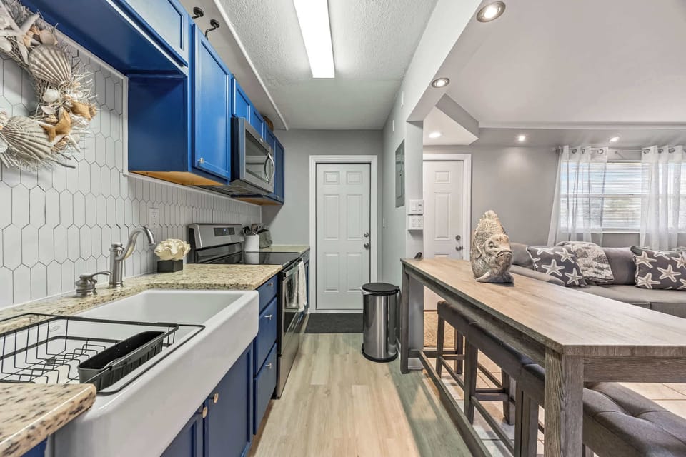 Modern kitchen with blue cabinets and a farmhouse sink overlooking the living area.