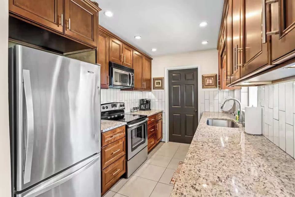 Modern kitchen with stainless steel appliances and granite countertops.