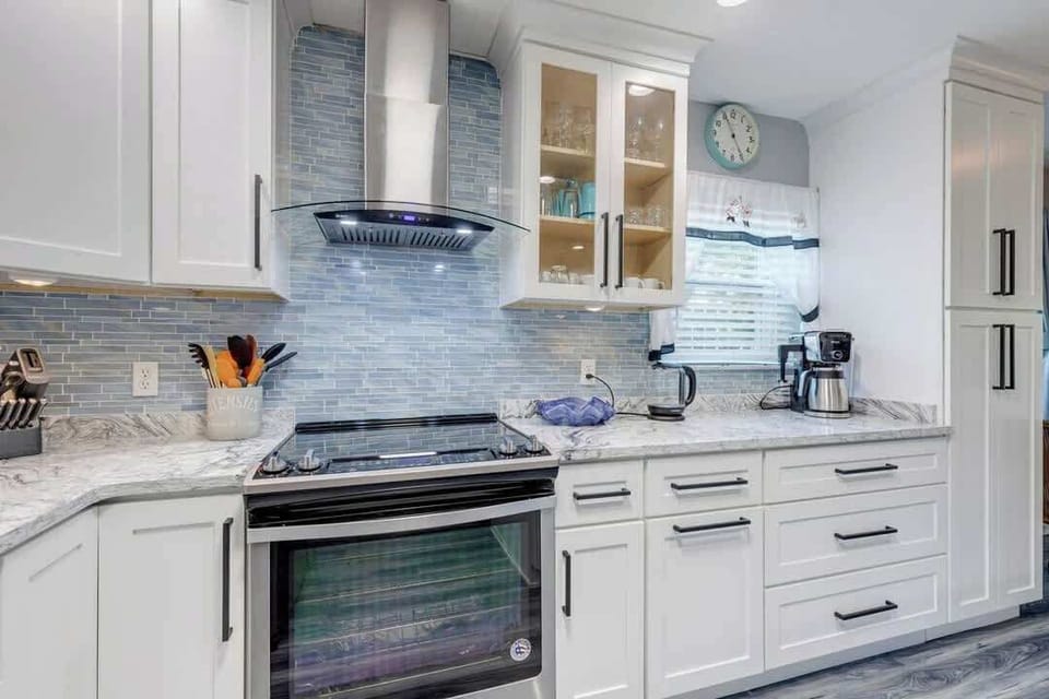 Modern kitchen with stainless steel stove and blue tile backsplash