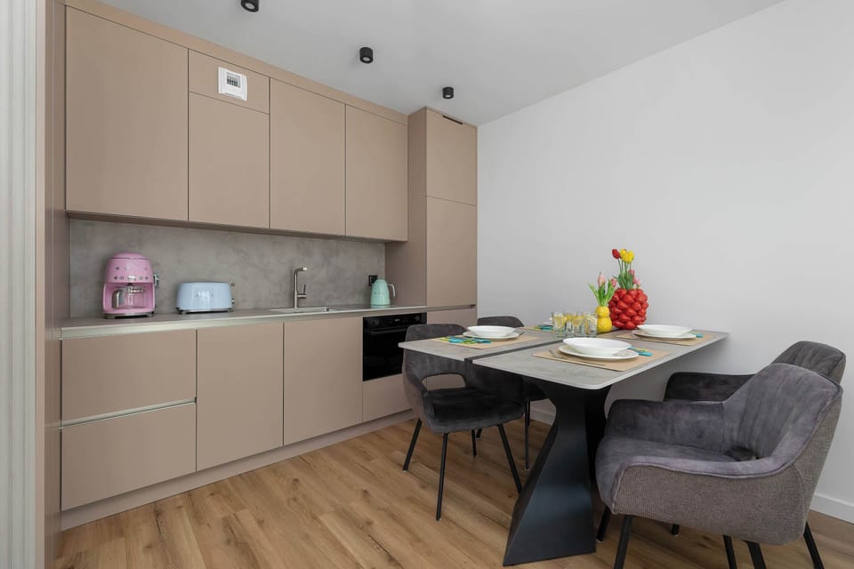 A compact dining and kitchenette space with light wood cabinetry and a small table set for meals.