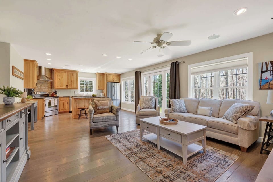 Relax in your open-concept living space where warm wood tones meet modern comfort, perfect for gathering after woodland adventures.