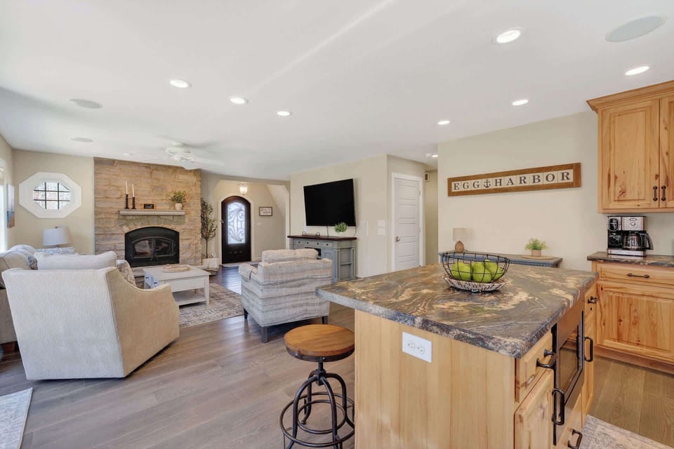 Unwind in your open-concept living space where rustic charm meets modern comfort—featuring a cozy fireplace, fully equipped kitchen, and plenty of room to relax.