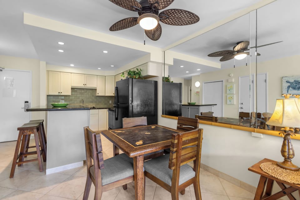 Your open-concept kitchen and dining area features modern appliances, tropical ceiling fans, and warm wood furnishings for memorable meals.