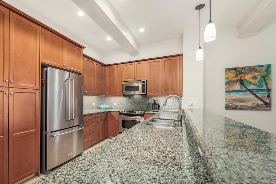 Your fully-equipped kitchen features granite countertops, stainless steel appliances, and warm wood cabinetry - perfect for preparing memorable meals during your stay.