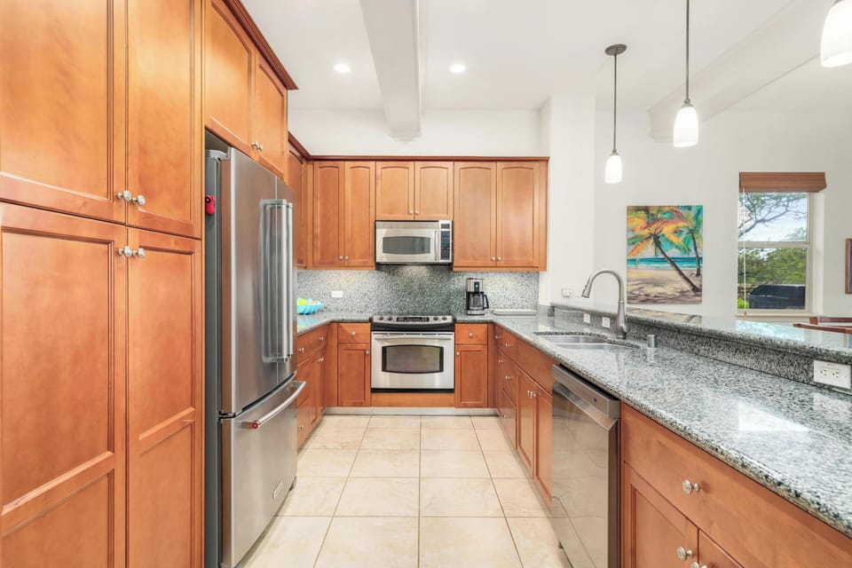 Your fully equipped kitchen features granite countertops, stainless steel appliances, and warm wood cabinetry—perfect for creating memorable meals during your stay.