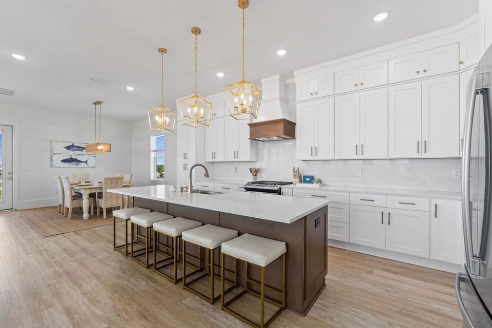 Your gourmet kitchen awaits with gleaming white cabinets, quartz countertops, and a spacious island perfect for morning coffee or evening cocktails.