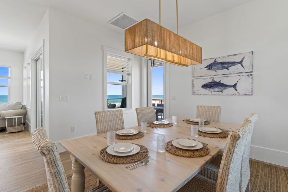 Gather around this coastal dining table where ocean views frame every meal, creating the perfect backdrop for memorable dinners.