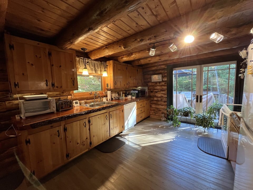 Cook your favorite meals in this charming rustic kitchen with exposed beams, modern appliances, and peaceful garden views.