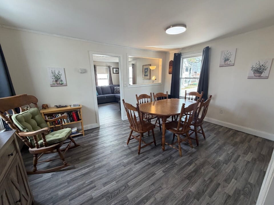 Step into your charming dining area with rustic wood table and cozy reading nook—perfect for family meals and quiet moments.