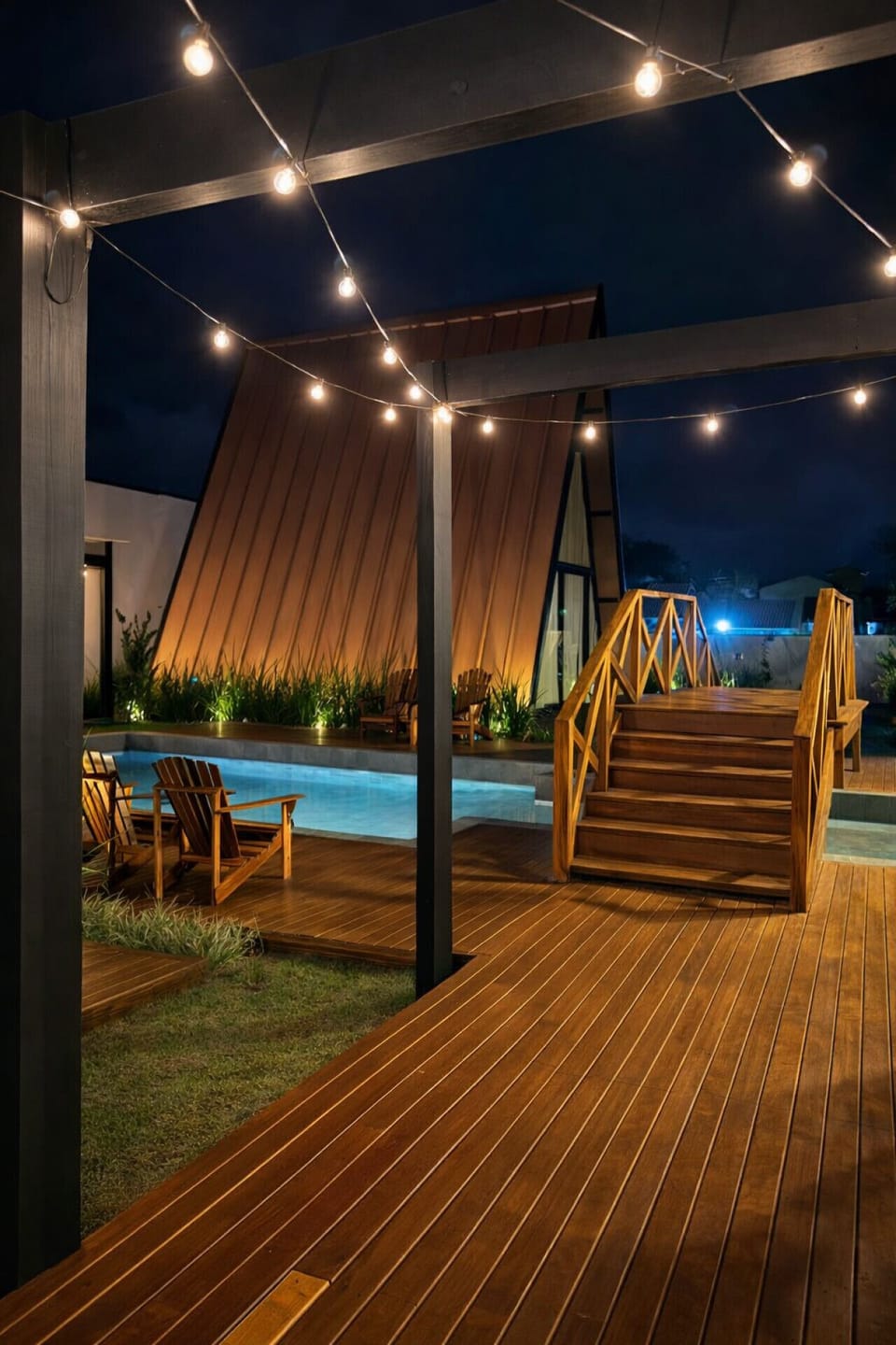 Área externa com escada em madeira e piscina privativa iluminada, ideal para relaxar com total privacidade.