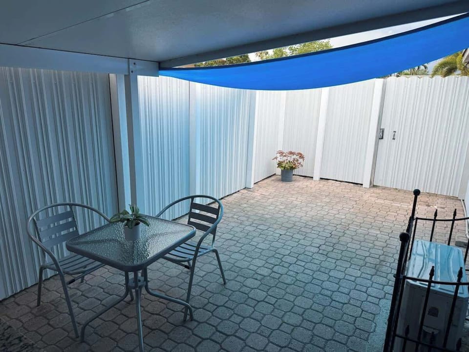Private fenced patio with BBQ, sink, and outdoor dining for relaxed evenings.