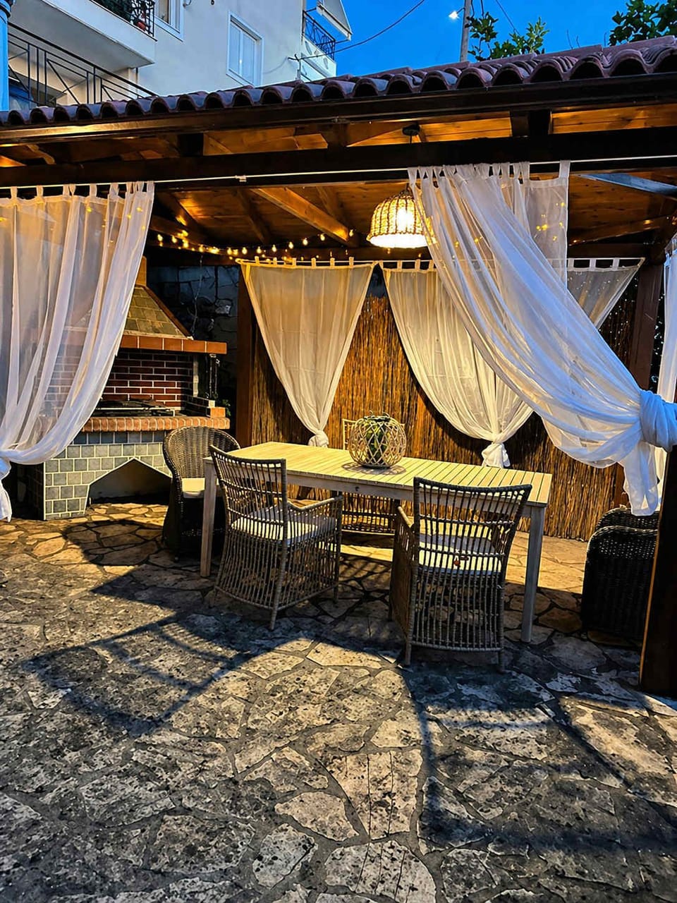 Private outdoor lounge area with shade, natural stone details, and a BBQ for relaxed alfresco dining