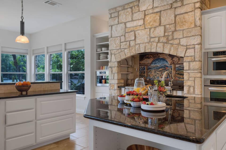 Stone range hood and breakfast spread on the island
