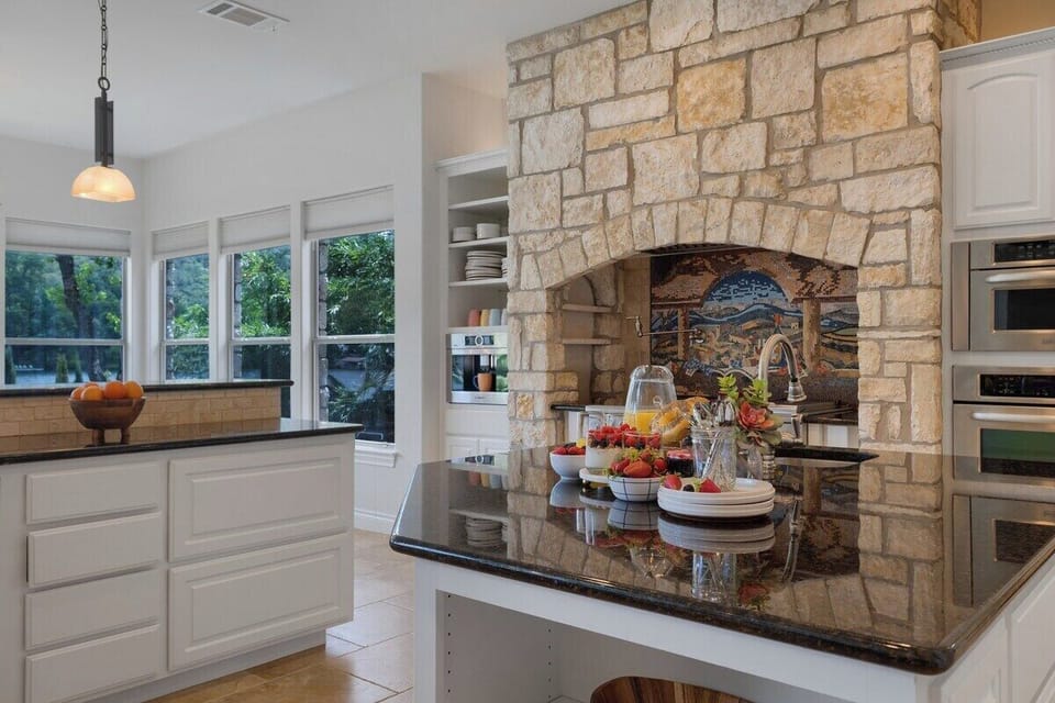 Stone range hood and breakfast spread on the island
