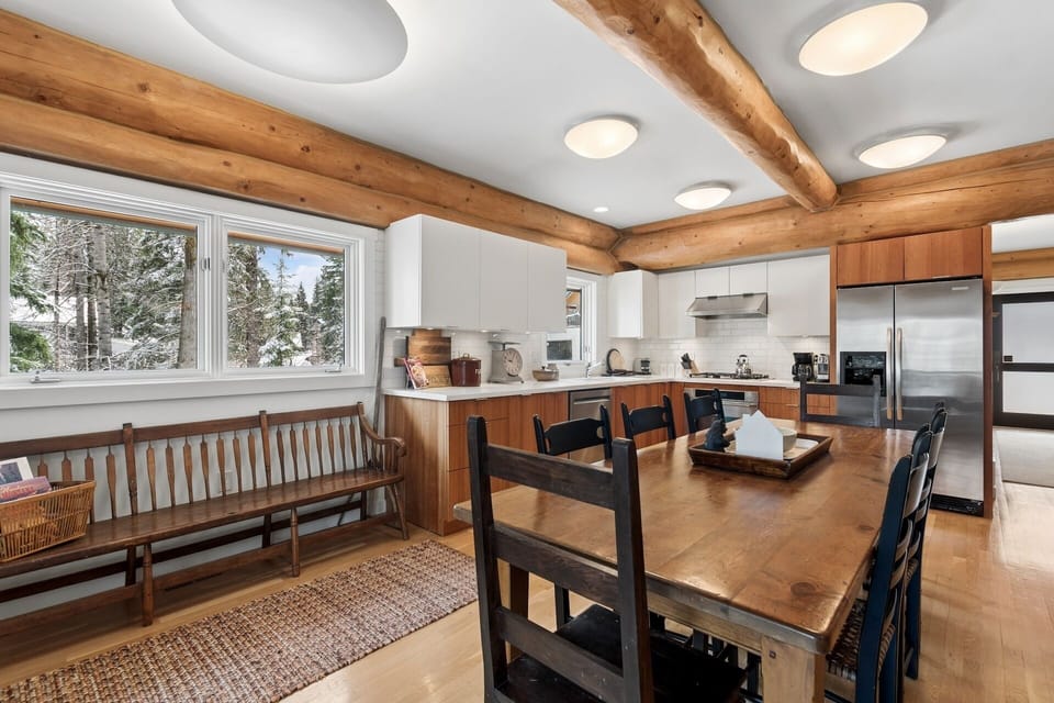 Gather around your spacious dining table in this rustic-modern kitchen, where exposed beams and mountain views create the perfect atmosphere for shared meals.