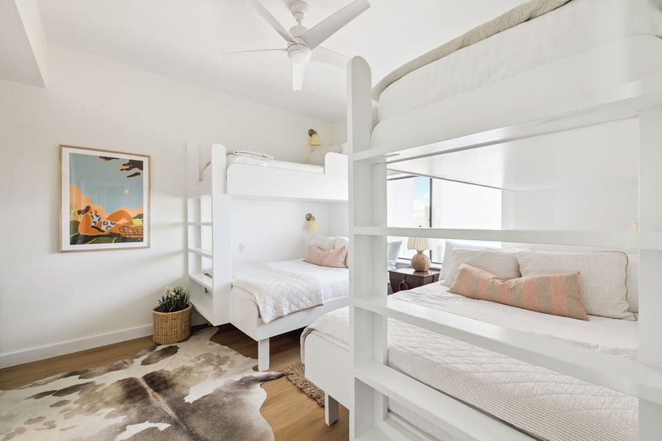 Sleep peacefully in these cozy bunk beds with soft linens and natural light streaming through large windows.