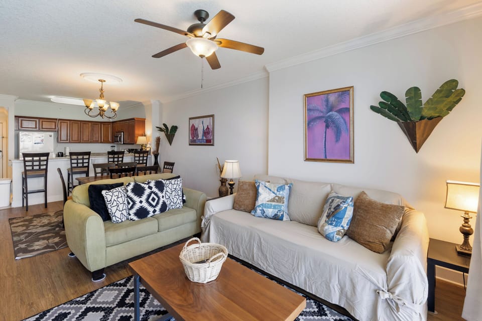 Relax in your coastal-themed living room with tropical artwork and comfortable seating for memorable vacation moments.