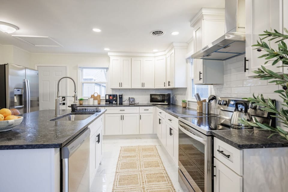 Spacious full kitchen with a cozy breakfast bar for two, featuring a fridge with ice maker and a well-stocked coffee bar—perfect for easy mornings and casual dining.
