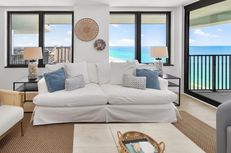 Coastal living room with stunning views of both the Gulf beach and the bay. A bright, stylish space to relax, gather, and enjoy sunrise-to-sunset scenery from your Panama City Beach getaway.