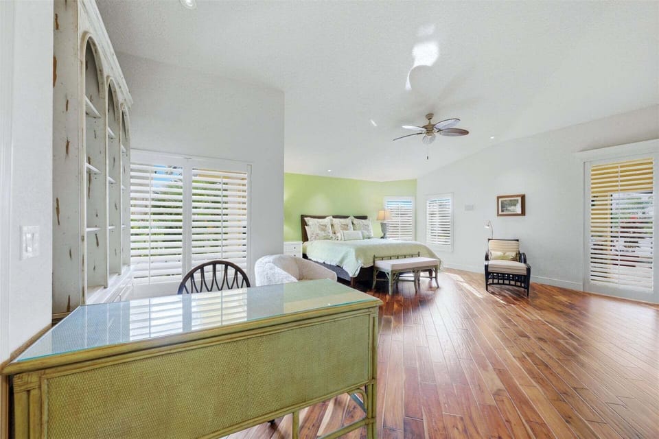 Huge primary bedroom with king bed, lanai acces, attached bathroom, desk & chair, and 55-inch Smart TV