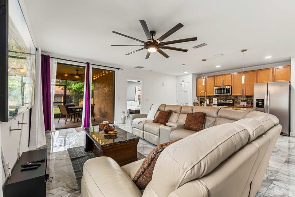 Spacious living room with leather sectional & patio access