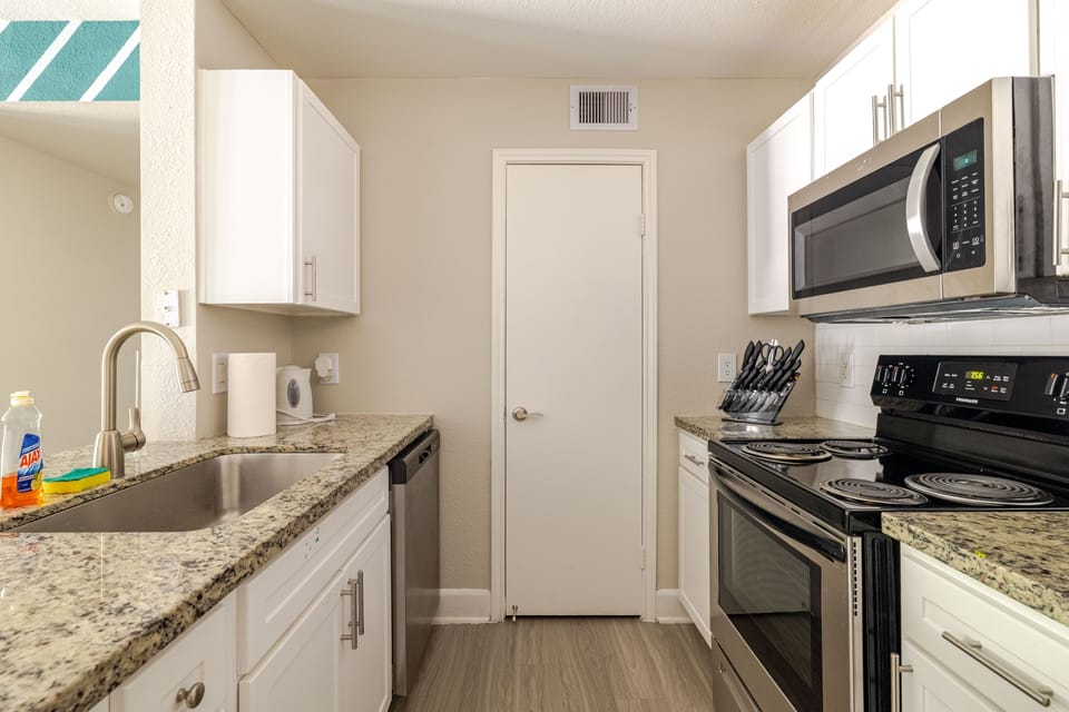 Bright modern kitchen with granite counters and stainless appliances