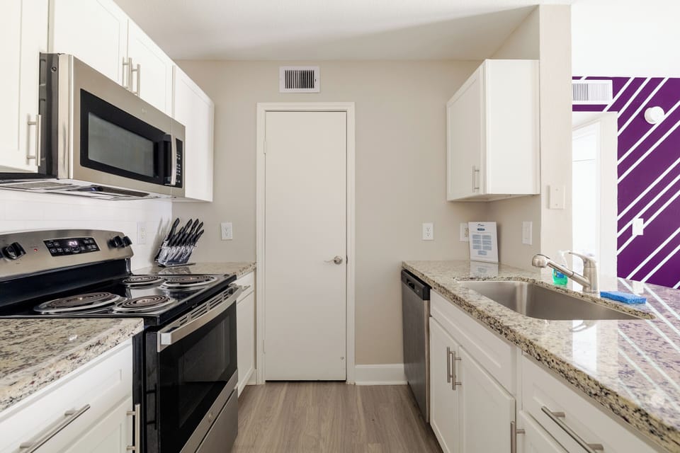 Bright modern kitchen with granite counters and stainless appliances