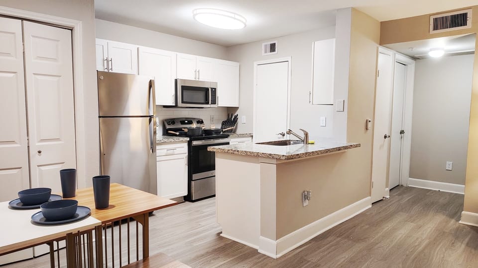 Bright modern kitchen with stainless appliances and open dining area