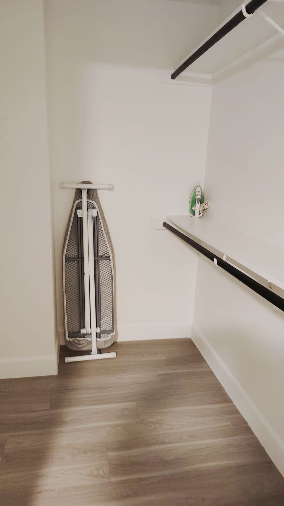 Walk-in closet with iron, ironing board, and ample hanging space