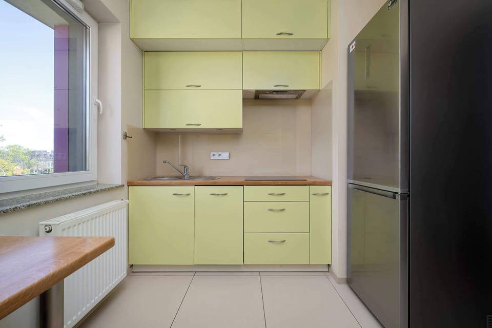 A spacious kitchen corner with extended countertops and upper cabinets, ideal for cooking and meal preparation. The neutral tones and clean design create a modern, practical atmosphere.