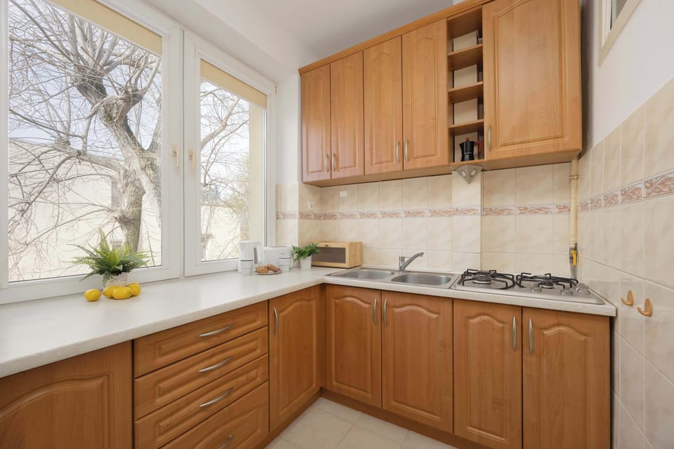 A kitchen with wooden cabinets and a light countertop. The space looks practical and well-lit for everyday use.