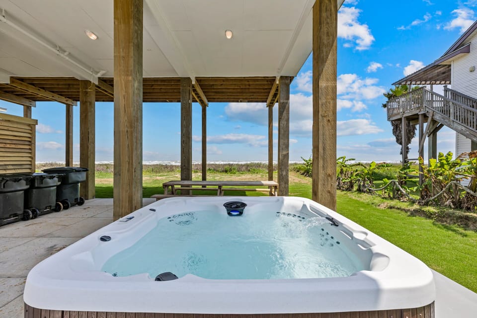 Luxury private hot tub with beachfront views and covered outdoor lounge area for relaxing Gulf Coast vacation experiences.