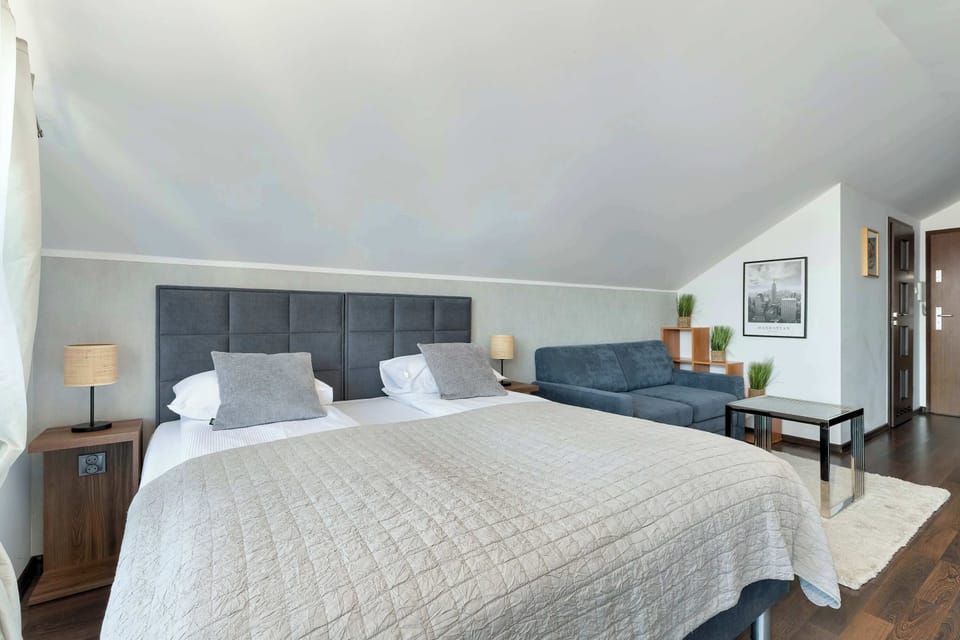 A bedroom view highlighting a neatly made double bed and modern furnishings. The design focuses on simplicity and comfort.