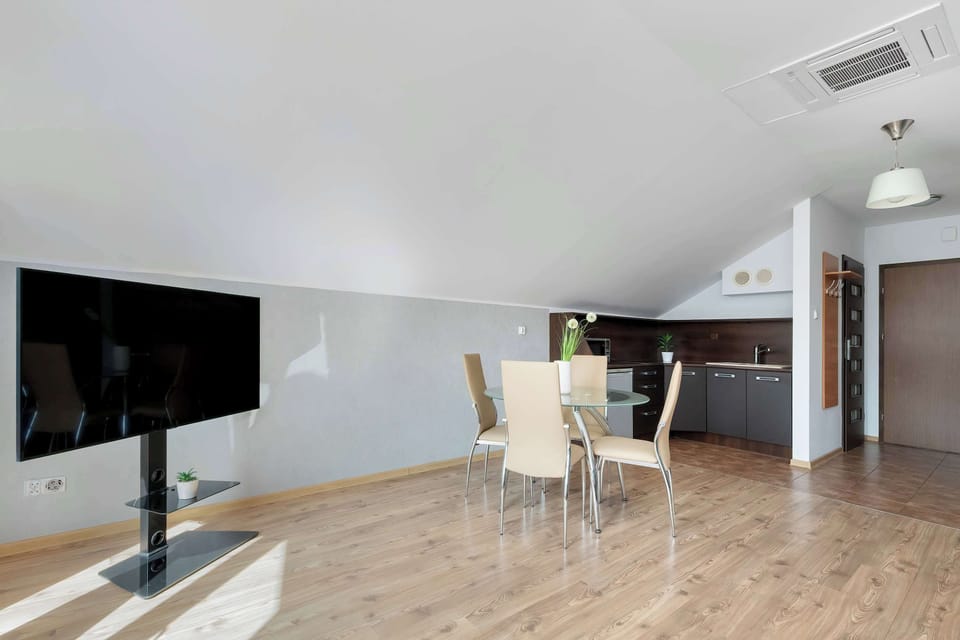 A modern dining and living area with a TV setup and a clean, functional layout. It feels practical yet stylish for everyday use.